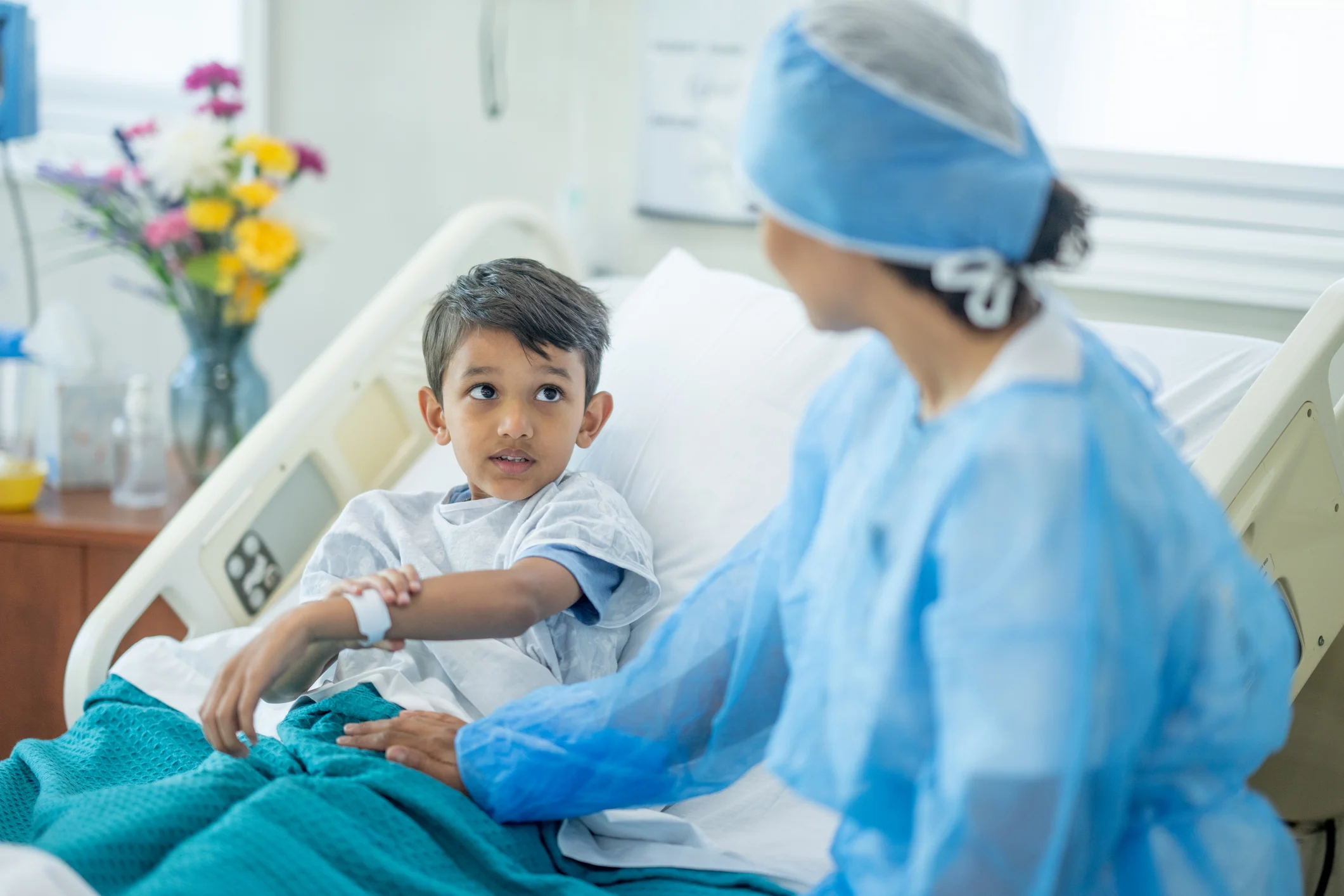 Doctor checking in on young child patient after surgery